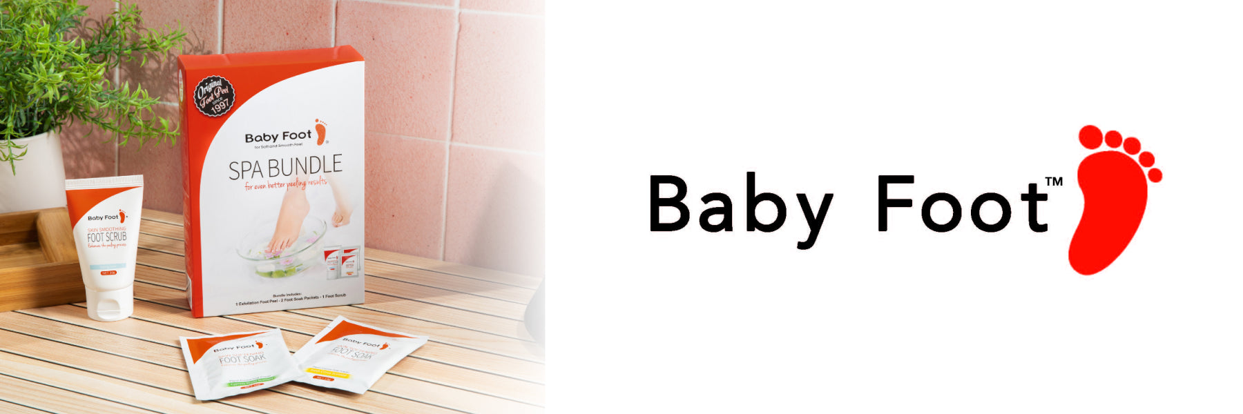A box of Baby Foot in a spa bathroom with a bamboo bench, pink tile, and a plant, with the Baby Foot logo nearby.