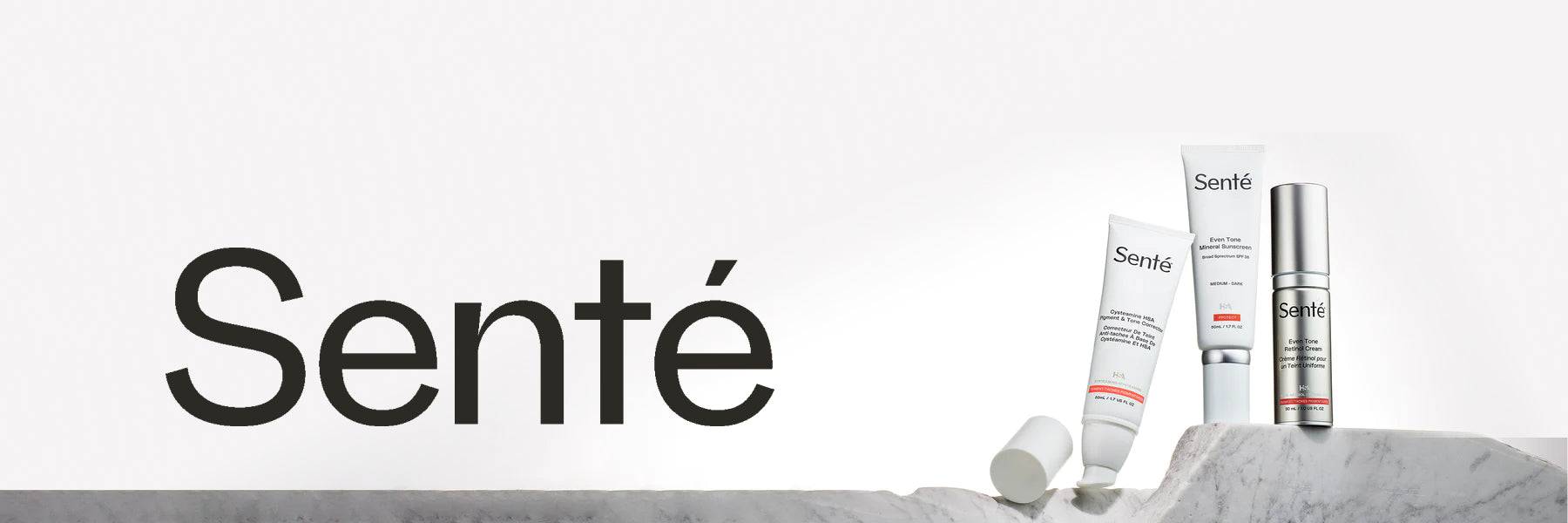 Three Sente products stand on a rough piece of stone in front of a white backdrop, with the Sente logo to the left.
