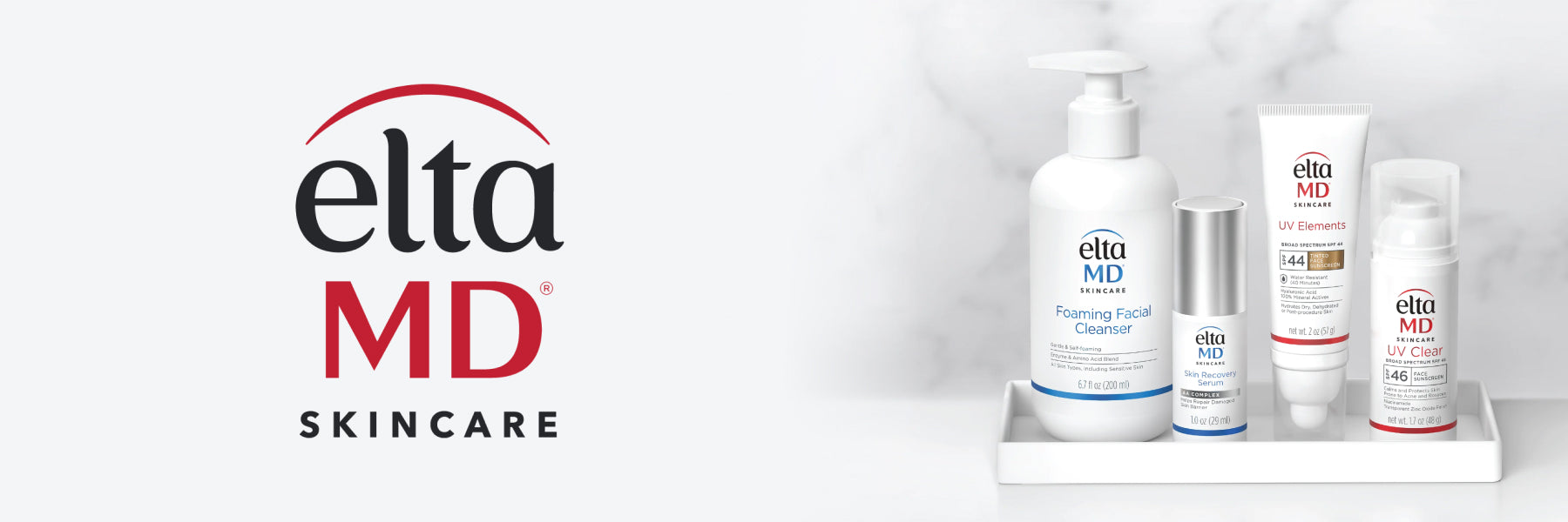 4 EltaMD products sit in a white tray against a grey marble backdrop, next to the EltaMd logo.