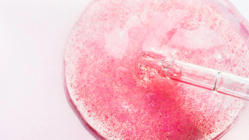 Closeup on a transparent pink serum that contains ceramides