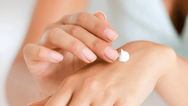 Closeup on a pair of hands as a person rubs in a white hand cream